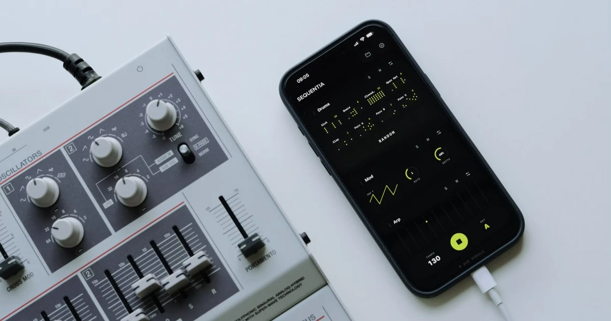 Smartphone running a tone generator app next to an analog audio mixer.