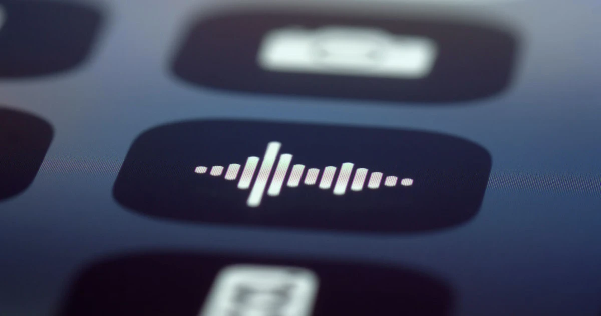 Sound wave icon on a blurred smartphone screen.