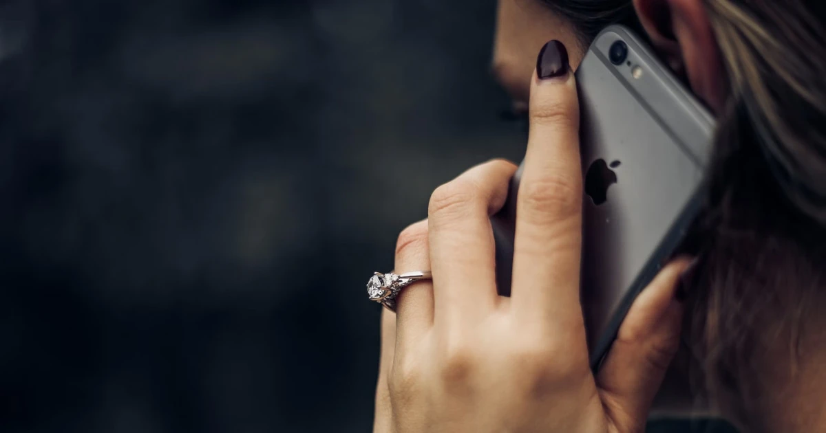 Woman holding an iPhone to her ear during a call.