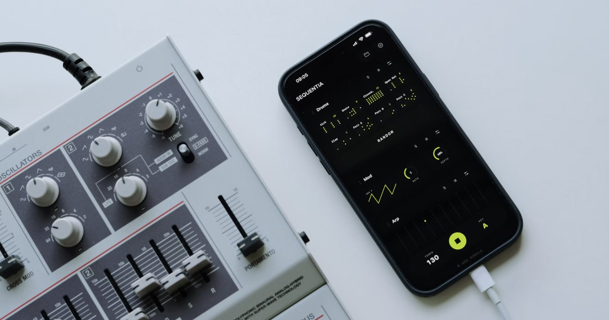 Smartphone running a tone generator app next to an analog audio mixer.