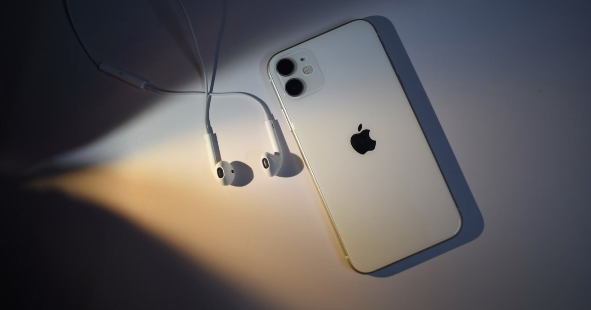 iPhone with wired earbuds dangling beside it.